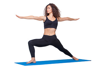 Image showing Studio shot of a young fit woman doing yoga exercises.