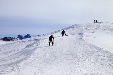 Image showing Skiers on ski slope at wind day