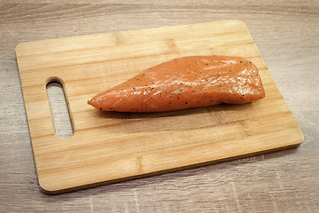 Image showing smoked turkey meat on wooden chopping board 
