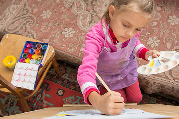 Image showing Top view risuyuschuyu five-year girl on an easel in the studio of the artist