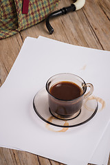 Image showing Coffee cup, paper sheets and detective hat