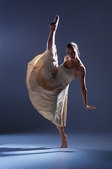 Image showing Young beautiful dancer in beige dress dancing on gray background