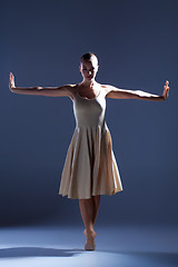 Image showing Young beautiful dancer in beige dress dancing on gray background