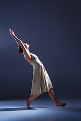 Image showing Young beautiful dancer in beige dress dancing on gray background