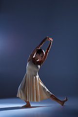 Image showing Young beautiful dancer in beige dress dancing on gray background