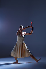 Image showing Young beautiful dancer in beige dress dancing on gray background