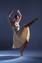 Image showing Young beautiful dancer in beige dress dancing on gray background