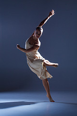 Image showing Young beautiful dancer in beige dress dancing on gray background