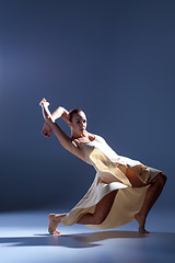 Image showing Young beautiful dancer in beige dress dancing on gray background