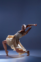 Image showing Young beautiful dancer in beige dress dancing on gray background