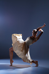 Image showing Young beautiful dancer in beige dress dancing on gray background