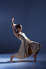 Image showing Young beautiful dancer in beige dress dancing on gray background