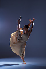 Image showing Young beautiful dancer in beige dress dancing on gray background