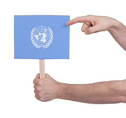 Image showing Hand holding small card - Flag of the UN