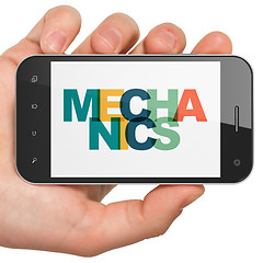 Image showing Science concept: Hand Holding Smartphone with Mechanics on  disp