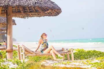 Image showing Woman sunbathing on tropical beach.