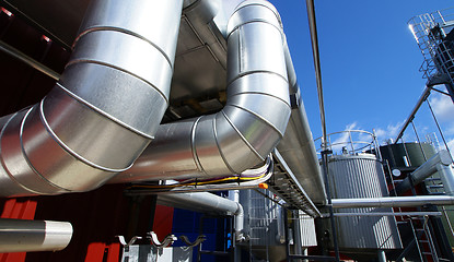 Image showing industrial pipelines on pipe-bridge against blue sky 