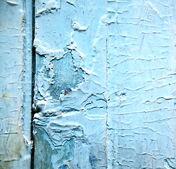 Image showing dirty stripped paint in the blue wood door and rusty nail