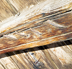 Image showing metal nail dirty stripped paint in the brown   red wood door and