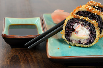 Image showing Black sushi rolls served on turquoise plate