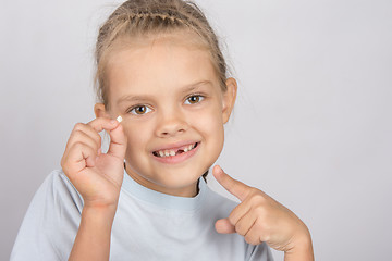 Image showing Six year old girl with a smile, pointing at the fallen baby tooth