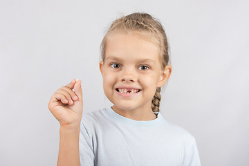Image showing The girl proudly showing her fallen baby tooth