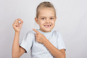 Image showing Smiling girl shows a finger on a fallen baby tooth