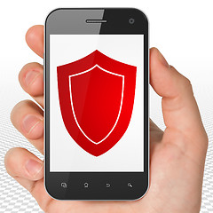 Image showing Safety concept: Hand Holding Smartphone with Shield on display