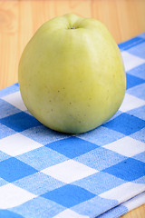 Image showing Fresh green apple on blue material backgound
