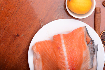 Image showing Raw salmon fish steaks with fresh herbs on white plate