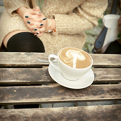 Image showing cup of coffee latte on a wooden table