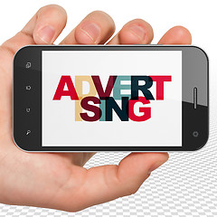 Image showing Marketing concept: Hand Holding Smartphone with Advertising on  display