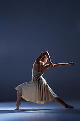 Image showing Young beautiful dancer in beige dress dancing on gray background