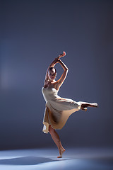 Image showing Young beautiful dancer in beige dress dancing on gray background