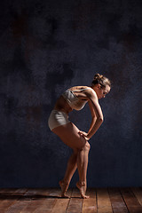 Image showing Young beautiful dancer in beige swimwear dancing on lilac background