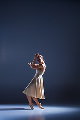 Image showing Young beautiful dancer in beige dress dancing on gray background