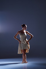 Image showing Young beautiful dancer in beige dress dancing on gray background