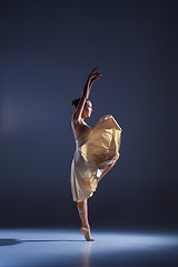 Image showing Young beautiful dancer in beige dress dancing on gray background