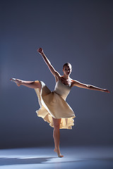 Image showing Young beautiful dancer in beige dress dancing on gray background