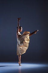 Image showing Young beautiful dancer in beige dress dancing on gray background