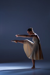 Image showing Young beautiful dancer in beige dress dancing on gray background