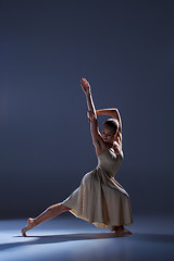 Image showing Young beautiful dancer in beige dress dancing on gray background