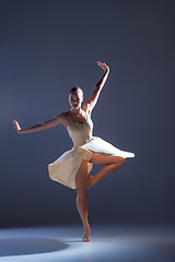 Image showing Young beautiful dancer in beige dress dancing on gray background