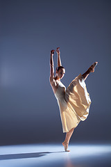 Image showing Young beautiful dancer in beige dress dancing on gray background