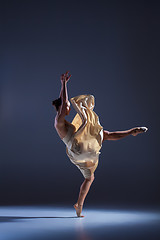 Image showing Young beautiful dancer in beige dress dancing on gray background