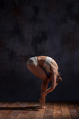 Image showing Young beautiful dancer in beige swimwear dancing on lilac background