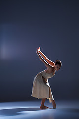 Image showing Young beautiful dancer in beige dress dancing on gray background