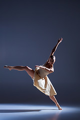 Image showing Young beautiful dancer in beige dress dancing on gray background