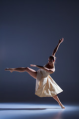 Image showing Young beautiful dancer in beige dress dancing on gray background