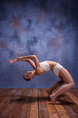 Image showing Young beautiful dancer in beige swimwear dancing on lilac background